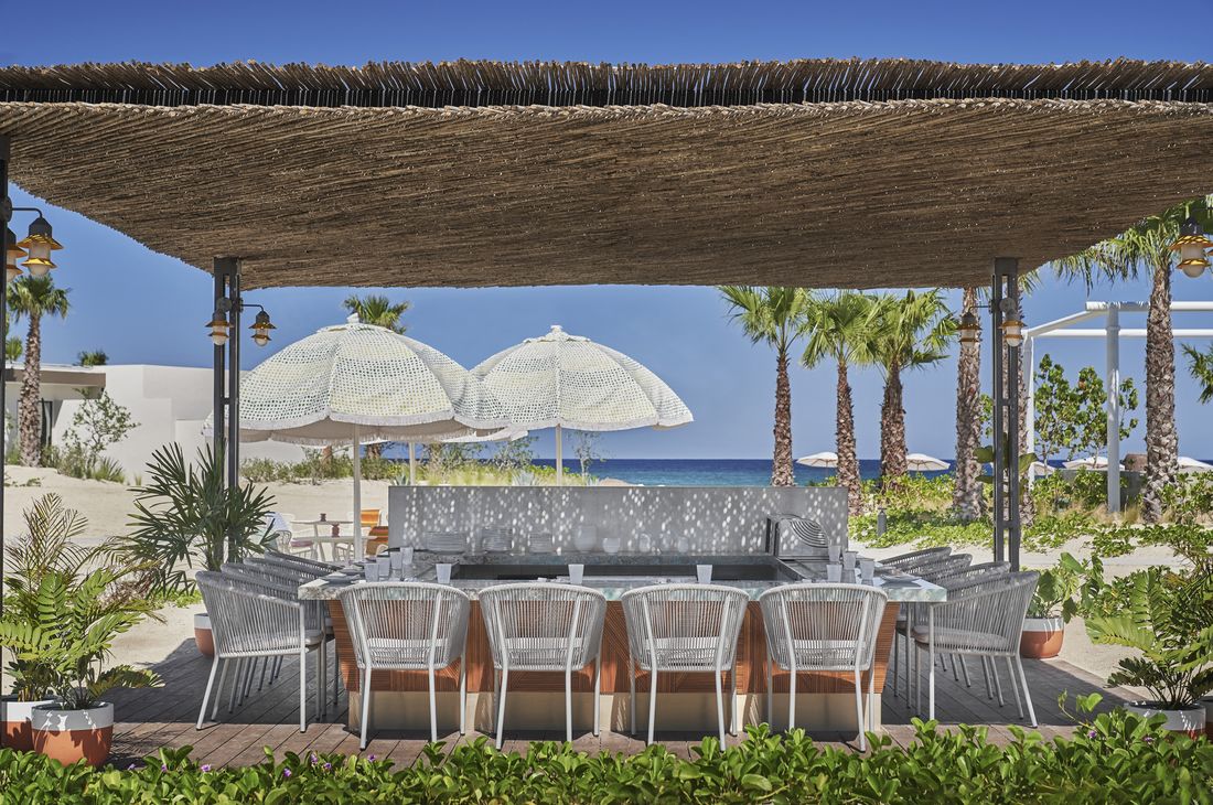 Comedor de playa bajo palapa de palma en Costa Palmas
