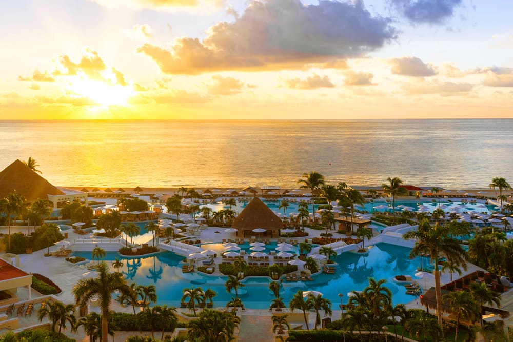 Alberca de Moon Palace Cancún al atardecer frente al mar