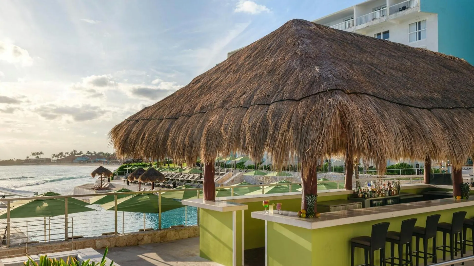 Bar de alberca con palapa frente al mar en The Westin Cancún Resort & Spa