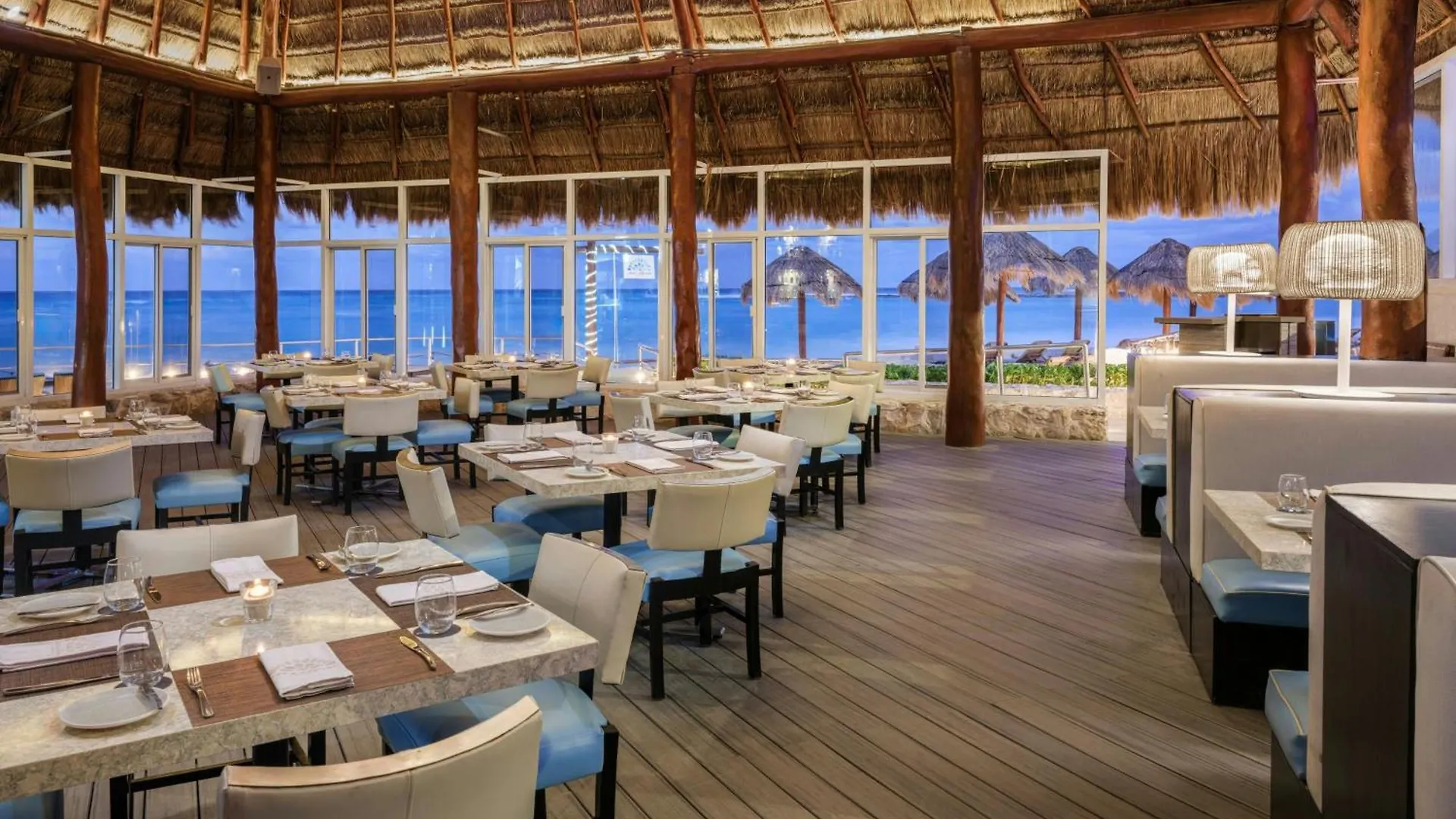 Restaurante con techo de palapa frente al mar en un resort Westin