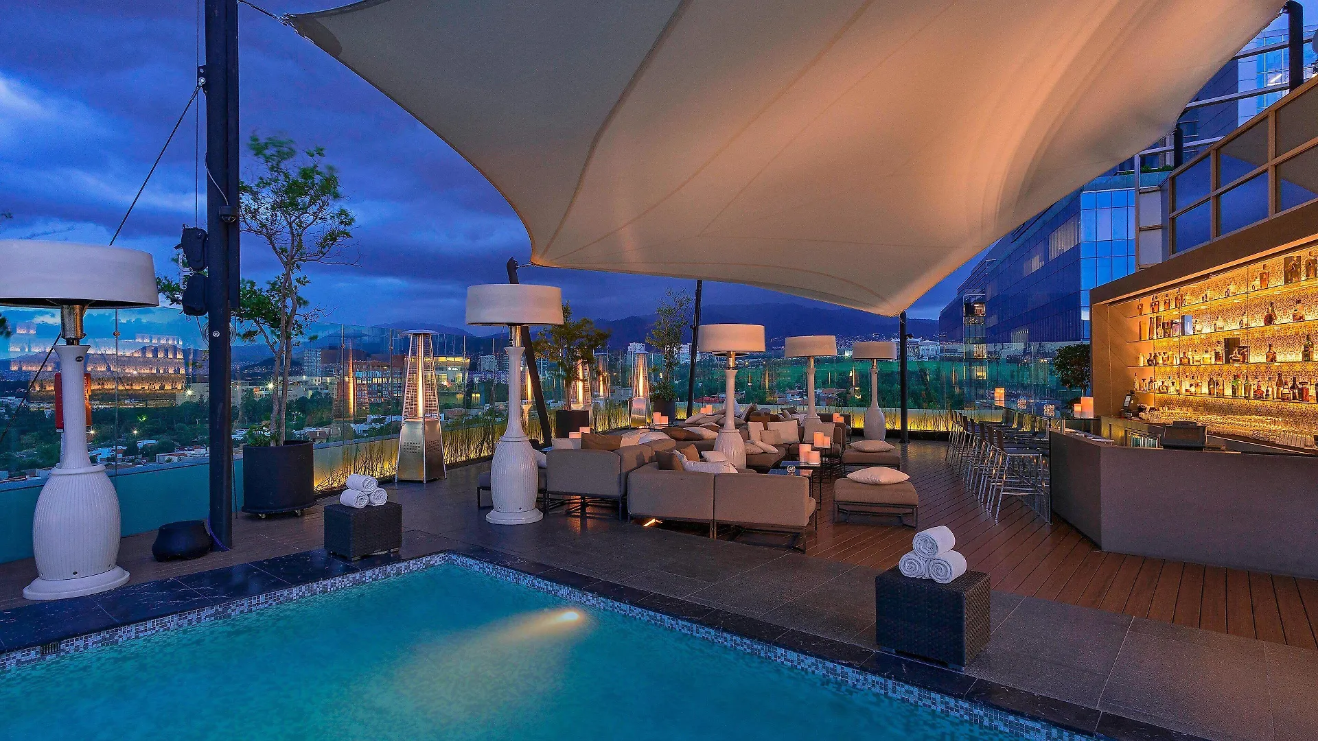 Alberca y bar de azotea de The Westin Santa Fe, Ciudad de México, al anochecer
